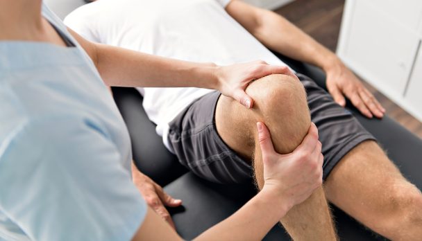 Patient at the physiotherapy doing physical exercises with his therapist