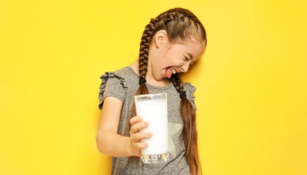Little,Girl,With,Dairy,Allergy,Holding,Glass,Of,Milk,On