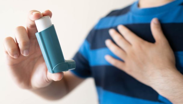 Young,Man,Using,Blue,Asthma,Inhaler,For,Relief,Asthma,Attack.