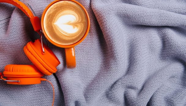 Cup,Of,Coffee,,Orange,Headphones,And,Blue,,Gray,Knitted,Sweater,