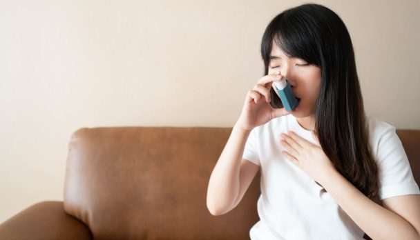 Young,Asian,Woman,Using,Blue,Asthma,Inhaler,For,Relief,Asthma